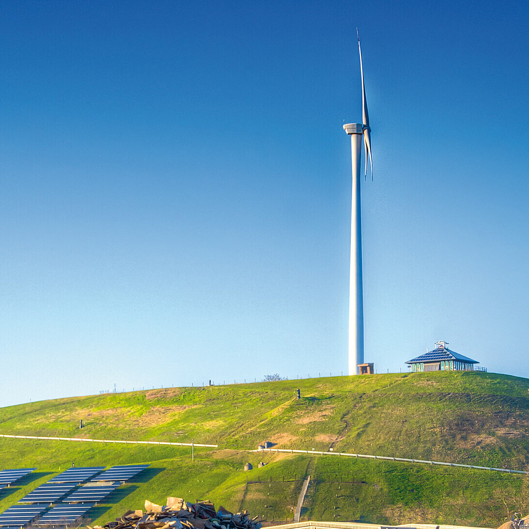 Müllberg im Umfeld des Rheinhafen Karlsruhe mit Windkraftanlage auf begrünter Anhöhe als Beispiel für Rekultivierung und nachhaltige Nutzung ehemaliger Deponieflächen.